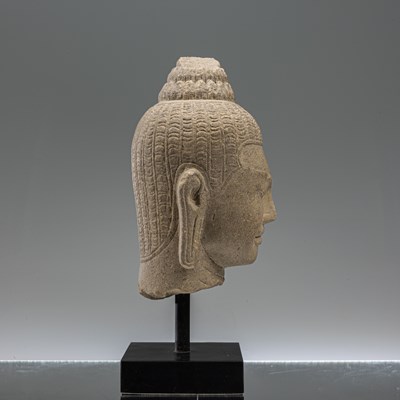 Lot 17 - SANDSTONE BAYON STYLE BUDDHA HEAD SOUTH-EAST ASIA 10TH CENTURY