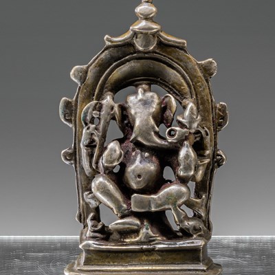 Lot 7 - INDIAN 16TH CENTURY SEATED SILVER GANESHA INSCRIBED AT THE BACK