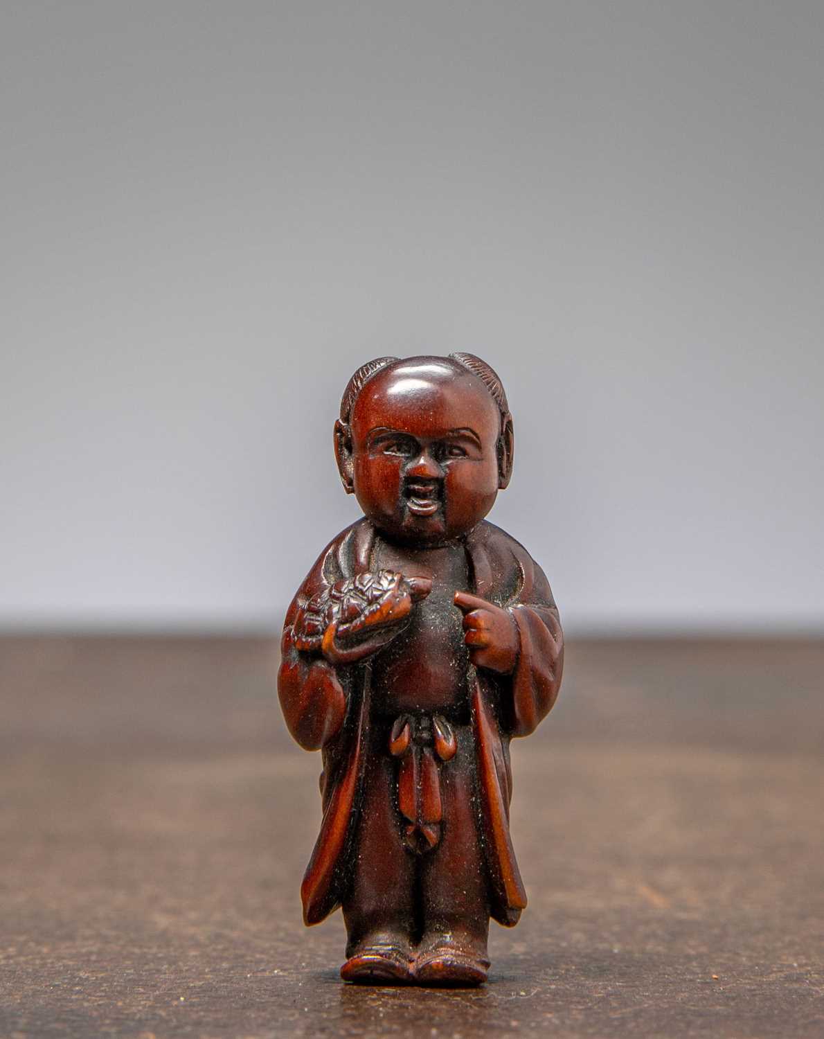 Lot 34 - (R) NETSUKE OF A BOY HOLDING A TORTOISE