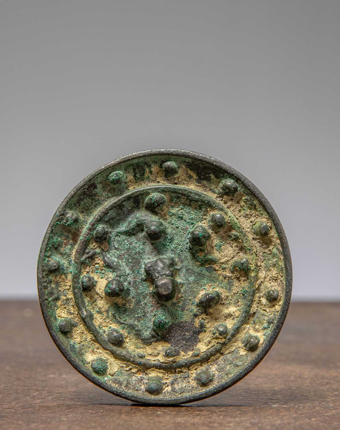 Lot 12 - (R)A CHINESE BRONZE MIRROR WITH KNOB , HAN DYNASTY (206 BCE - 220 CE)
