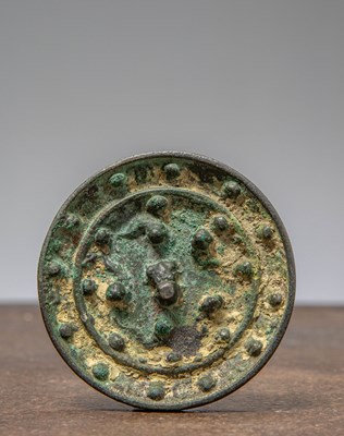 Lot 12 - (R)A CHINESE BRONZE MIRROR WITH KNOB , HAN DYNASTY (206 BCE - 220 CE)