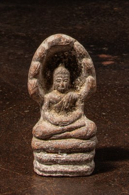 Lot 239 - A CLAY FIGURE OF THE BUDDHA PROTECTED BY MUCALINDA CIRCA 12TH CENTURY