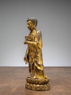 Lot 64 - A GILT-BRONZE BUDDHA HOLDING A VASE, CHINA LATE MINGY DYNASTY
