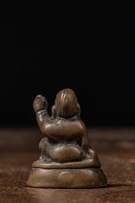 Lot 73 - A MINIATURE BRONZE FIGURE OF A MAHASIDDHA, PROBABLY VIRŪPA TIBET 13TH CENTURY