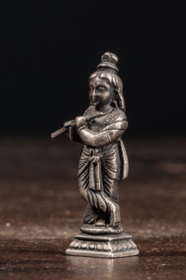 Lot 53 - (R) A SILVER FIGURE OF STANDING KRISHNA PLAYING THE FLUTE INDIA 19TH CENTURY