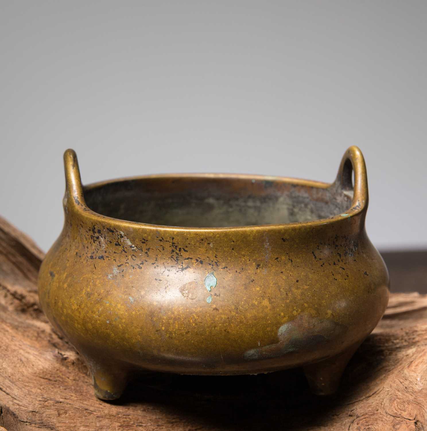 Lot 59 - A BRONZE TRIPOD CENSER WITH LOOP HANDLES CHINA, CAST WITH A XUANDE MARK