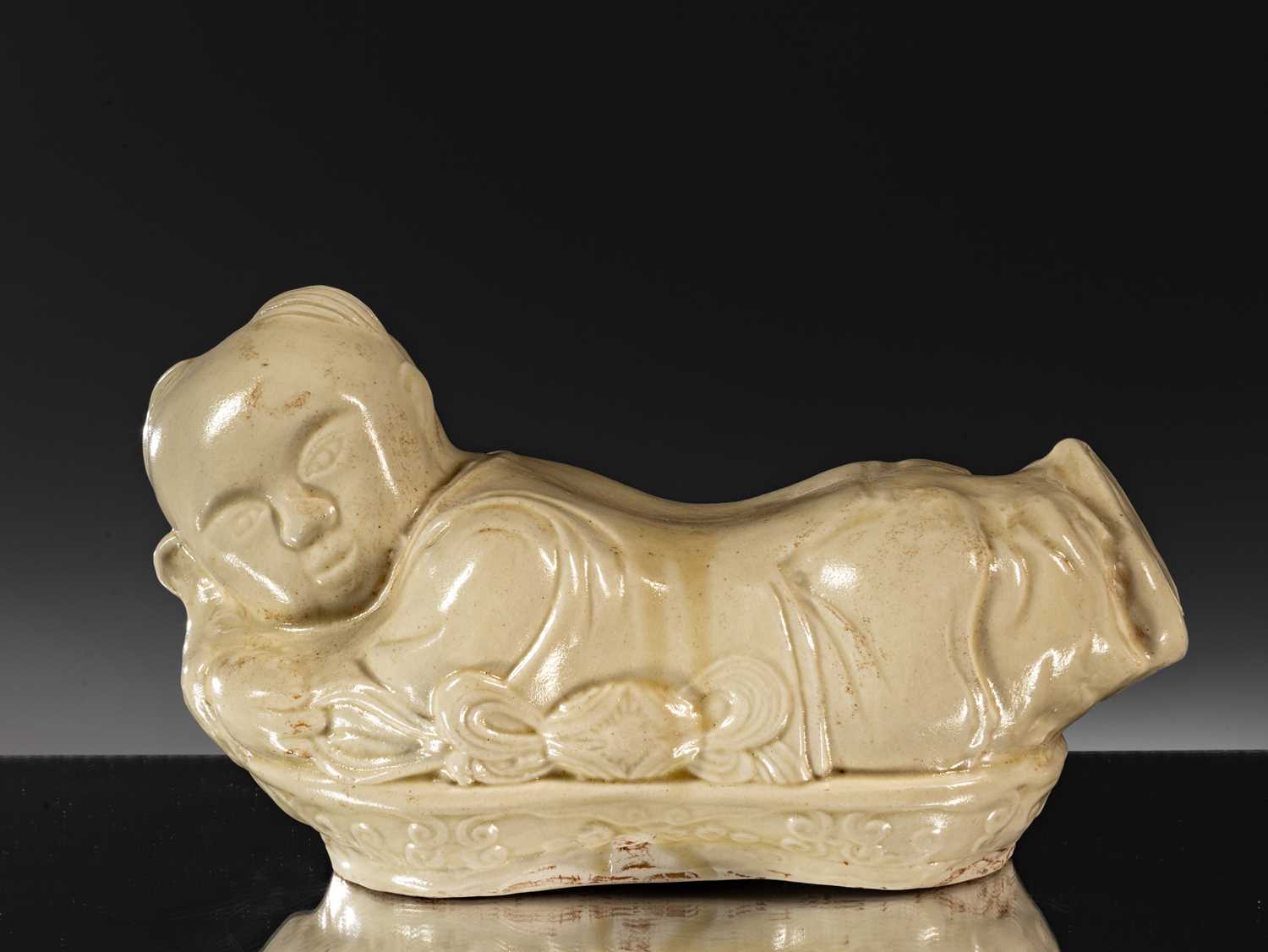 Lot 95 - PORCELAIN TING WARE WHITE CERAMIC PILLOW IN THE SHAPE OF A CHILD CHINA YUAN DYNASTY (1271-1368)