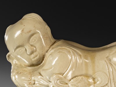 Lot 95 - PORCELAIN TING WARE WHITE CERAMIC PILLOW IN THE SHAPE OF A CHILD CHINA YUAN DYNASTY (1271-1368)
